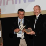 J. Kirkpatrick receiving the award from M. Barbosa, president of the award committee, and L. Ambrosio, ESB president